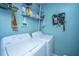 Functional laundry room with washer, dryer, shelving, and organized tool storage at 1401 Elm Hall Cir, Summerville, SC 29483