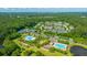 Aerial view showcases the community with mature trees, neighborhood homes, multiple pools, tennis courts, and amenities at 1409 Bloomingdale Ln, Mount Pleasant, SC 29466