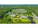 Aerial view showcases the community with mature trees, neighborhood homes, multiple pools, tennis courts, and amenities at 1409 Bloomingdale Ln, Mount Pleasant, SC 29466