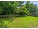 This backyard features a well-manicured lawn, lush trees, and a white picket fence at 1409 Bloomingdale Ln, Mount Pleasant, SC 29466