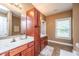 Bathroom with double vanity, wood cabinets, and natural light from the window at 1409 Bloomingdale Ln, Mount Pleasant, SC 29466
