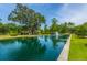 Community pond with fountain, lush greenery, mature trees, and a building in the background at 1409 Bloomingdale Ln, Mount Pleasant, SC 29466