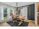 Bright dining area with a rustic wood table, modern chandelier, and sleek black accent wall at 141 Tall Pines Rd, Ladson, SC 29456