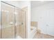 Bright bathroom featuring glass shower, tub with tiled surround, and stool at 145 Pier View St # 214, Daniel Island, SC 29492