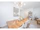 Bright dining room featuring modern chandelier and wood table, with an open view to the kitchen at 145 Pier View St # 214, Daniel Island, SC 29492