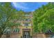 Exterior shot of a four-story condo building with balconies and manicured trees at 145 Pier View St # 214, Daniel Island, SC 29492