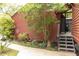 An entrance to the home featuring red siding, a short stairway, landscaped surroundings, and an outdoor shower area at 152 Mansfield Blvd, Charleston, SC 29418
