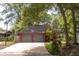 Charming exterior of red home featuring an attached two-car garage, long driveway, and landscaping at 152 Mansfield Blvd, Charleston, SC 29418