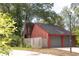 Exterior of red home with attached two-car garage, side yard, and mature trees at 152 Mansfield Blvd, Charleston, SC 29418