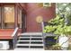 Covered stairs leading to the red wooden home featuring a decorative sun at 152 Mansfield Blvd, Charleston, SC 29418