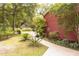 Charming home featuring a well-manicured lawn and a winding walkway leading to the entrance, surrounded by lush greenery at 152 Mansfield Blvd, Charleston, SC 29418
