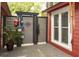 Patio area with wooden fence, nautical themed decorations, and a small potted plant, and red siding on the home at 152 Mansfield Blvd, Charleston, SC 29418