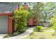 Side yard of red home featuring mature trees, walkway, and privacy fence at 152 Mansfield Blvd, Charleston, SC 29418