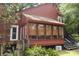 The rear exterior features a well-lit sunroom, artistic details, and stairs leading to the garden with native plants at 152 Mansfield Blvd, Charleston, SC 29418