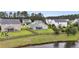 Lush fenced backyard featuring a screened porch overlooking the lawn and with a pond visible in the background at 173 Southport Dr, Summerville, SC 29483
