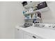 Functional laundry room with washer, dryer, and shelving for organized storage at 173 Southport Dr, Summerville, SC 29483