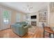 Spacious living room featuring hardwood floors, built-in bookshelves, fireplace, and access to outdoor living space at 183 Civitas St, Mount Pleasant, SC 29464