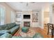 Comfortable living room featuring built-in bookshelves, a fireplace, and a green leather sofa set at 183 Civitas St, Mount Pleasant, SC 29464