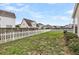 Large, grassy backyard enclosed by a white picket fence and wooden fence, offering privacy and space at 193 Cypress Forest Dr, Moncks Corner, SC 29461