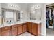 Bathroom featuring dual sinks, an extra-long countertop, wood cabinets, large mirrors, and a walk-in closet at 193 Cypress Forest Dr, Moncks Corner, SC 29461