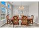 An elegant dining room featuring large windows, chandelier lighting, and sophisticated wood furniture at 193 Cypress Forest Dr, Moncks Corner, SC 29461
