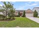 Beautiful exterior with a lush green lawn, mature trees, stone accents, and a two-car garage at 193 Cypress Forest Dr, Moncks Corner, SC 29461