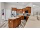 A modern kitchen with stainless steel appliances, wood cabinets, an island, and gray wood-look floors at 193 Cypress Forest Dr, Moncks Corner, SC 29461