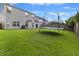 Expansive backyard featuring a large trampoline, lush lawn, and views of the home's rear facade at 2005 Isabela Ct, Summerville, SC 29483