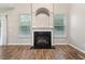 Bright living room featuring a black fireplace, modern wood floors, and natural light from the large windows at 2005 Isabela Ct, Summerville, SC 29483