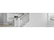 Staircase with white railings leading to a kitchen area with white cabinets and stainless steel appliances at 201 Terrace View Dr, Summerville, SC 29486
