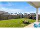 Spacious backyard with a well-maintained lawn, fire pit, and wooden fence at 215 Cypress Plantation Rd, Moncks Corner, SC 29461