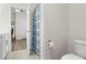 Open door reveals a shower with stylish curtain and a modern toilet with a view into another room at 215 Cypress Plantation Rd, Moncks Corner, SC 29461