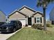 Charming one-story home featuring a well-manicured lawn, landscaped garden beds, and a driveway with a parked car at 215 Cypress Plantation Rd, Moncks Corner, SC 29461