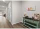 Bright hallway with wood floors, white doors, console table with decor and colorful artwork at 215 Cypress Plantation Rd, Moncks Corner, SC 29461