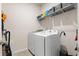 Well-organized laundry room with a white washer and dryer set and overhead shelving at 215 Cypress Plantation Rd, Moncks Corner, SC 29461