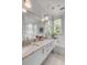 Bright bathroom featuring double sink vanity with marble countertop, soaking tub and tiled floors at 222 Haddrell St, Mount Pleasant, SC 29464
