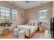 Bedroom with pink walls, wood floors, two windows and a bed with white linens at 222 Haddrell St, Mount Pleasant, SC 29464