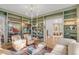 Charming living room with custom bookshelves, hardwood flooring, two comfy chairs, and a cream colored couch at 222 Haddrell St, Mount Pleasant, SC 29464