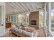 Inviting screened porch with comfortable seating, brick fireplace, and ceiling fan at 222 Haddrell St, Mount Pleasant, SC 29464
