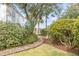 Landscaped walkway leading to a waterfront home, lined with lush greenery and mature trees at 222 Haddrell St, Mount Pleasant, SC 29464
