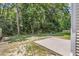 Expansive backyard featuring a concrete patio, lush greenery, mature trees, and a serene natural setting at 252 Island Green Rd, Goose Creek, SC 29445