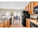Spacious kitchen featuring wood cabinets, black appliances, and a dining area with natural light at 252 Island Green Rd, Goose Creek, SC 29445