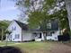 Charming white two-story home with a well-manicured lawn, palm trees, and mature trees in a serene setting at 27 Fitzroy Dr, Charleston, SC 29414