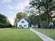 Beautiful white home with a well-maintained lawn, mature trees, and a walkway leading to the entrance at 27 Fitzroy Dr, Charleston, SC 29414