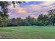 Scenic view of a lush green golf course with trees and sky with soft pastel colors in the background at 27 Fitzroy Dr, Charleston, SC 29414
