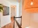 Hallway featuring hardwood floors, decorative light fixtures, and eye-catching modern artwork at 27 Fitzroy Dr, Charleston, SC 29414