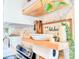 Decorated kitchen with open shelving, neutral wallpaper, stainless steel appliances, and a wooden paper towel holder at 27 Fitzroy Dr, Charleston, SC 29414