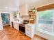 Modern kitchen featuring stainless steel appliances, a farmhouse sink, floating shelves, and herringbone flooring at 27 Fitzroy Dr, Charleston, SC 29414