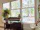 Sunlit living space with piano, fern, and view of the backyard with chairs at 27 Fitzroy Dr, Charleston, SC 29414