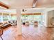 Open floor plan with large windows, beamed ceilings, comfortable seating and sunroom access at 27 Fitzroy Dr, Charleston, SC 29414
